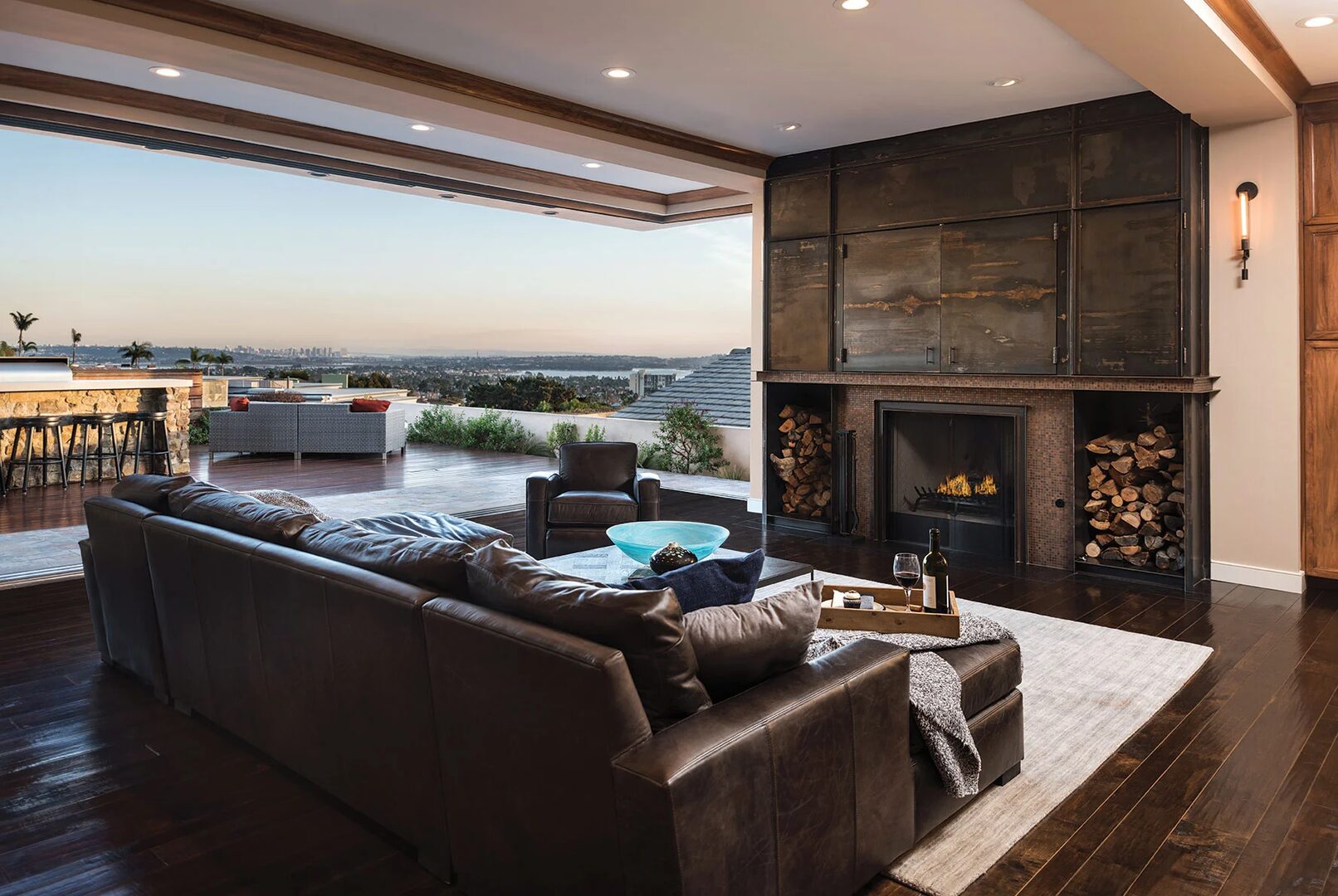 Elegant San Diego luxury living room with leather seating, fireplace, and panoramic indoor-outdoor views